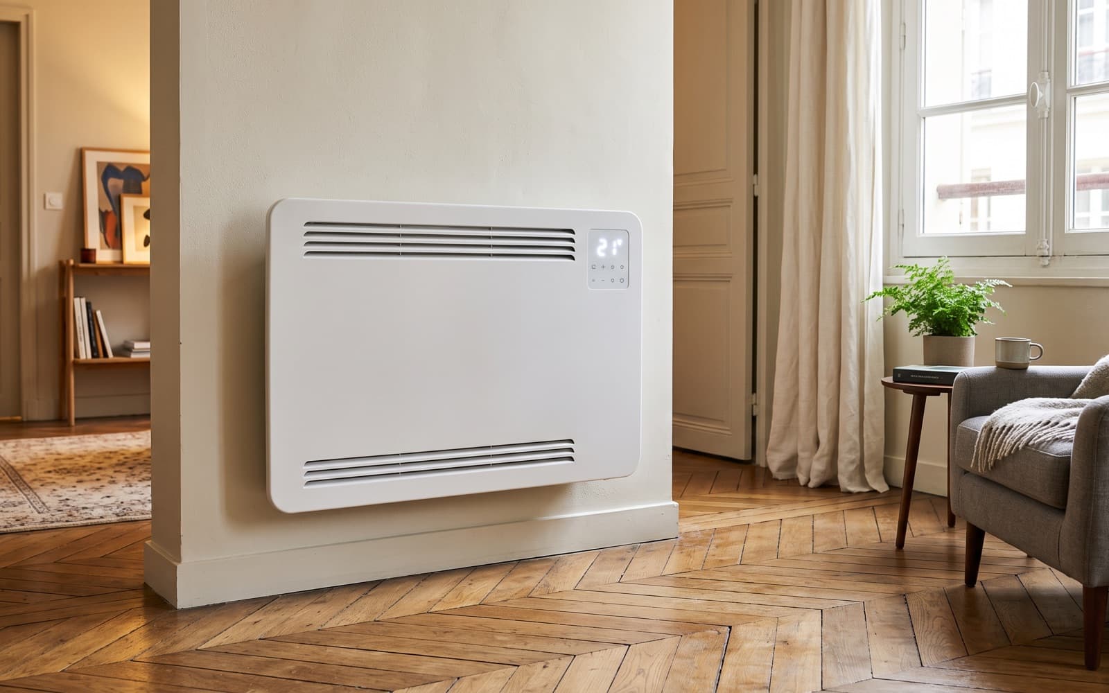 Radiateur électrique mural moderne blanc avec afficheur digital, dans un salon au parquet ancien